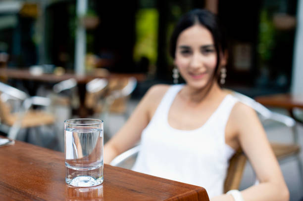 Person pouring fresh water into a glass at home